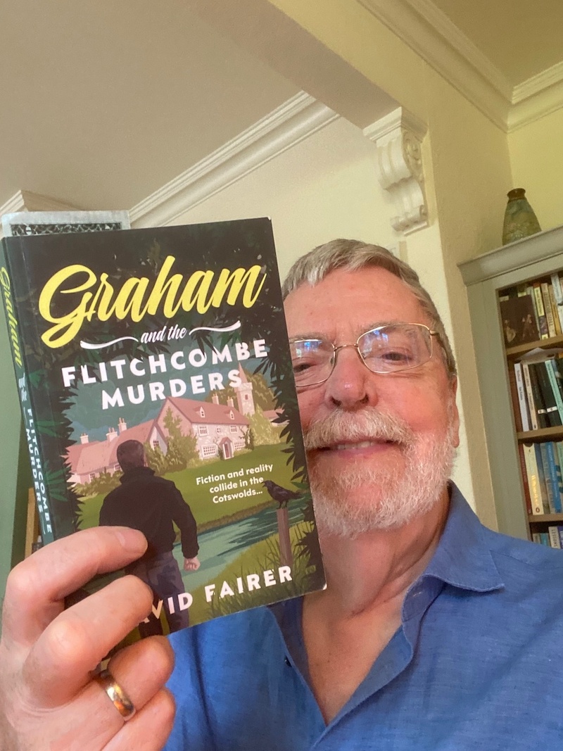 Crime fiction author David Fairer holding his novel Graham and the Flitchcombe Murders