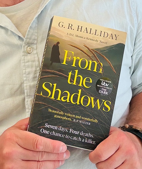 hands holding a copy of From the Shadows by GR Halliday