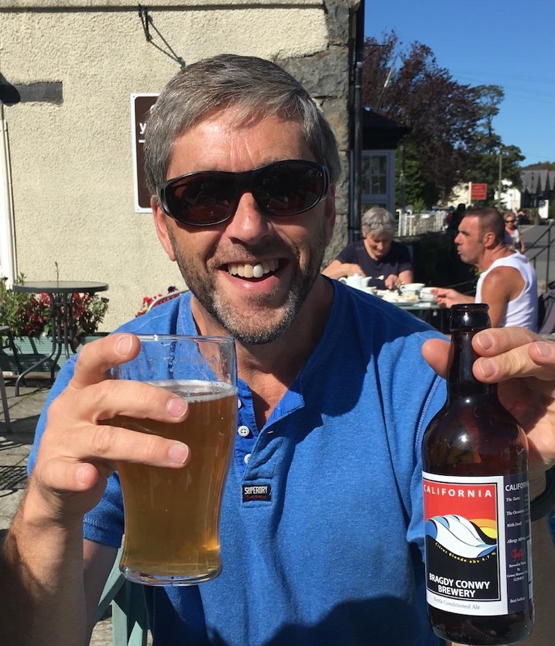 British crime fiction author Philip Swan holding a glass of beer